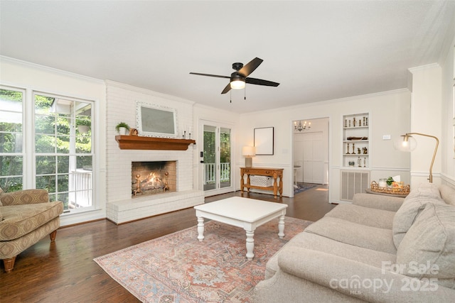 139 Palaside Dr NE, Concord, NC 28025 - living area with crown molding, wood finished floors, a ceiling fan, built in features, and a fireplace