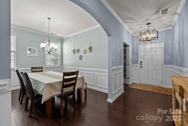 1569 Shannon Falls Dr, Fort Mill, SC 29715 - dining room with a chandelier, arched walkways, dark wood-type flooring, a decorative wall, and a wainscoted wall