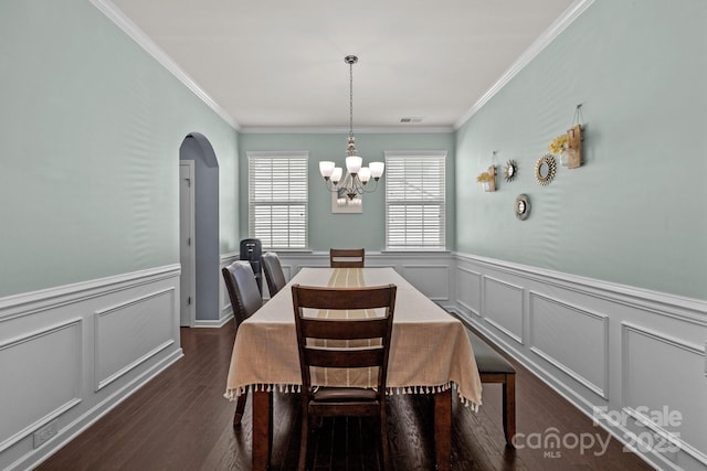 1569 Shannon Falls Dr, Fort Mill, SC 29715 - dining area featuring a decorative wall, wainscoting, a chandelier, crown molding, and dark wood-type flooring