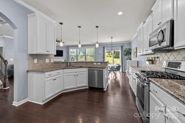1569 Shannon Falls Dr, Fort Mill, SC 29715 - kitchen featuring stainless steel appliances, a peninsula, ornamental molding, backsplash, and white cabinetry