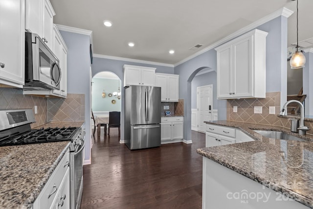 1569 Shannon Falls Dr, Fort Mill, SC 29715 - kitchen featuring appliances with stainless steel finishes, arched walkways, decorative backsplash, stone counters, and crown molding