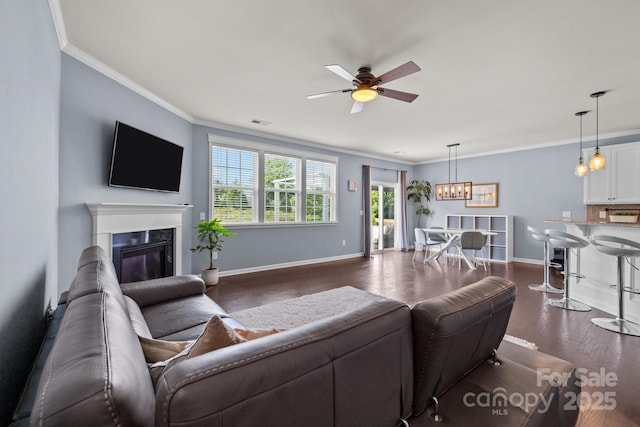 1569 Shannon Falls Dr, Fort Mill, SC 29715 - living area featuring ceiling fan, dark wood-type flooring, a fireplace, crown molding, and a chandelier
