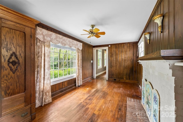 805 S Main St, Mount Holly, NC 28120 - unfurnished living room featuring hardwood / wood-style flooring, a ceiling fan, ornamental molding, and wooden walls