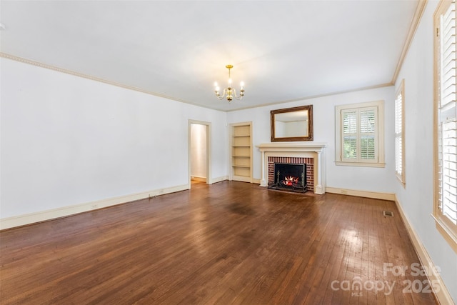 805 S Main St, Mount Holly, NC 28120 - unfurnished living room with wood-type flooring, a chandelier, crown molding, a fireplace, and built in features