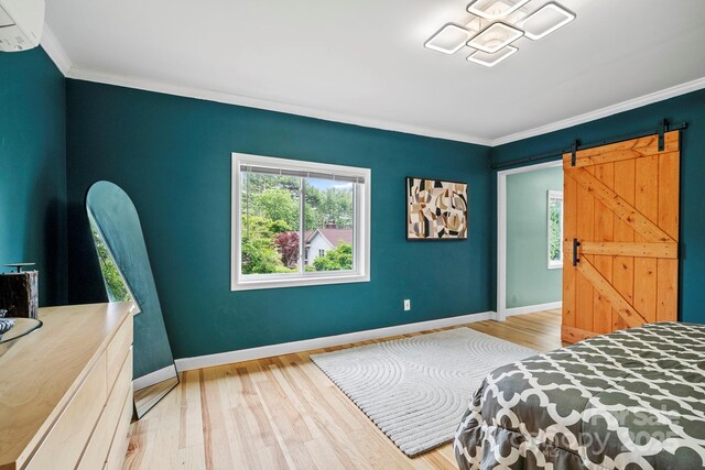 419 E Blue Ridge Rd, East Flat Rock, NC 28726 - bedroom featuring crown molding, wood finished floors, a barn door, and a wall mounted air conditioner