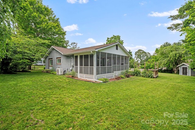 419 E Blue Ridge Rd, East Flat Rock, NC 28726 - rear view of property featuring a storage shed, a sunroom, and a yard