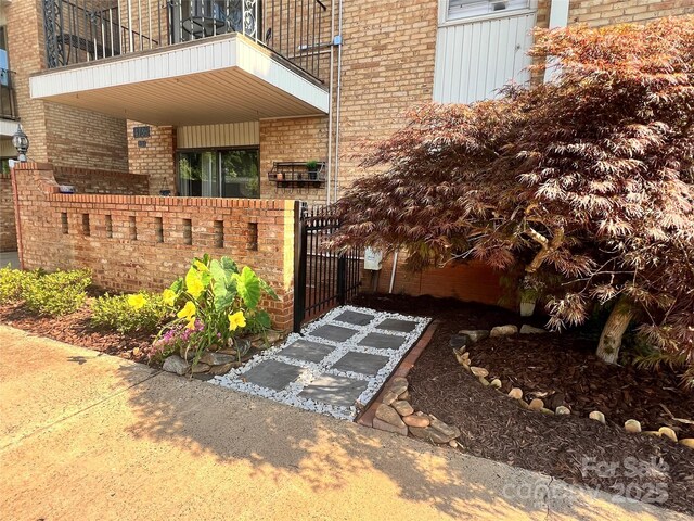 4736 Hedgemore Dr Unit K, Charlotte, NC 28209 - property entrance featuring brick siding, a balcony, and a gate
