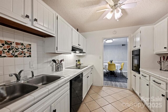 4736 Hedgemore Dr Unit K, Charlotte, NC 28209 - kitchen with black appliances, tile countertops, white cabinets, decorative backsplash, and a textured ceiling