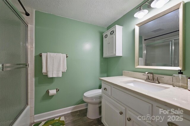 4736 Hedgemore Dr Unit K, Charlotte, NC 28209 - full bathroom featuring vanity, a textured ceiling, shower / bath combination with glass door, and wood finished floors