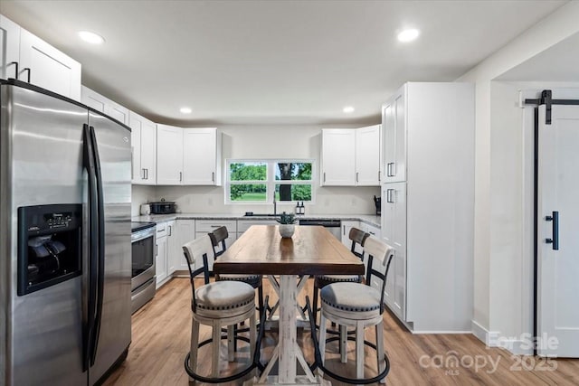 5740 Crouse Rd, Crouse, NC 28033 - kitchen featuring stainless steel appliances, light wood-style floors, white cabinets, recessed lighting, and light stone counters
