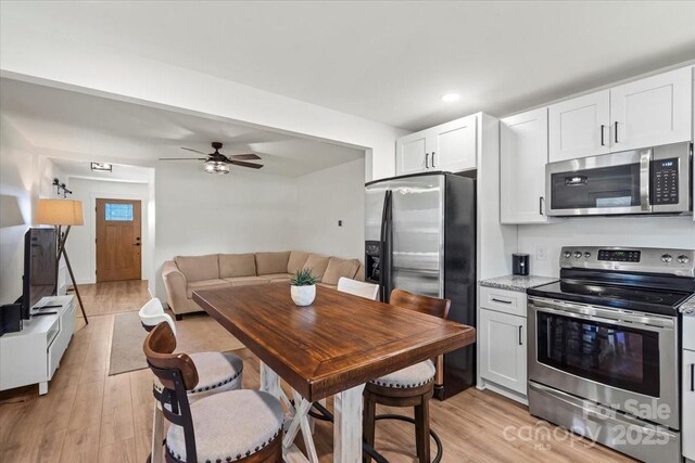 5740 Crouse Rd, Crouse, NC 28033 - kitchen featuring stainless steel appliances, light wood-type flooring, white cabinetry, open floor plan, and recessed lighting