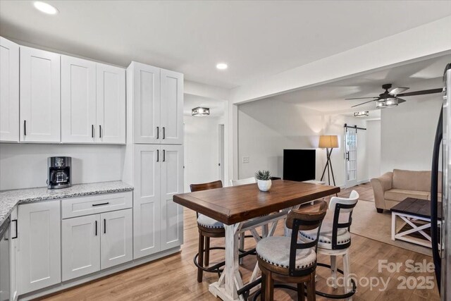 5740 Crouse Rd, Crouse, NC 28033 - dining room featuring a barn door, recessed lighting, light wood-style floors, and a ceiling fan