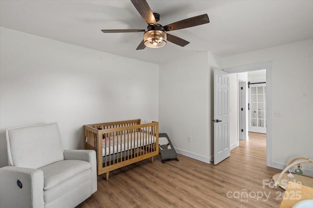 5740 Crouse Rd, Crouse, NC 28033 - bedroom with wood finished floors, ceiling fan, and a nursery area