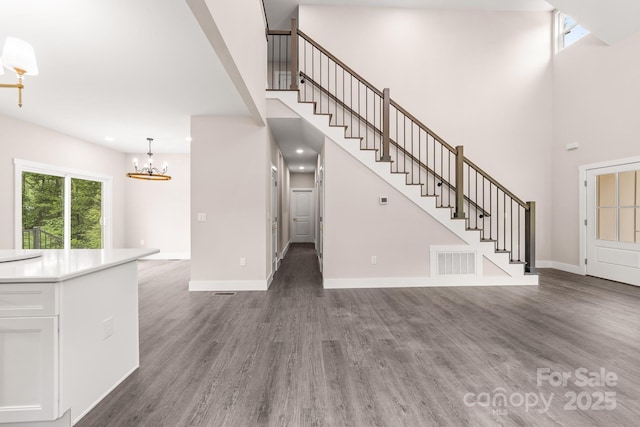 1471 Marshbrooke Ln, Catawba, NC 28609 - unfurnished living room featuring a towering ceiling, stairway, wood finished floors, and a chandelier