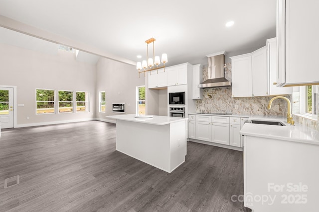1471 Marshbrooke Ln, Catawba, NC 28609 - kitchen with wall chimney exhaust hood, black appliances, decorative backsplash, a center island, and white cabinets