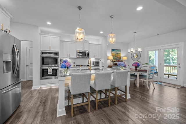 322 Ethan Ln, Rock Hill, SC 29732 - kitchen featuring appliances with stainless steel finishes, white cabinets, dark wood-style flooring, recessed lighting, and a kitchen bar