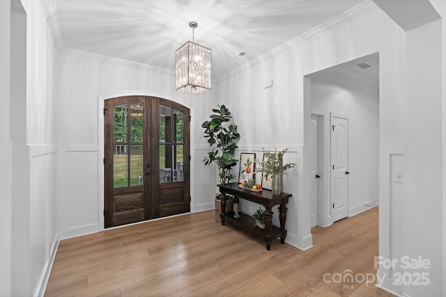 8283 Long Island Rd, Catawba, NC 28609 - foyer entrance featuring arched walkways, crown molding, french doors, light wood-style flooring, and a chandelier