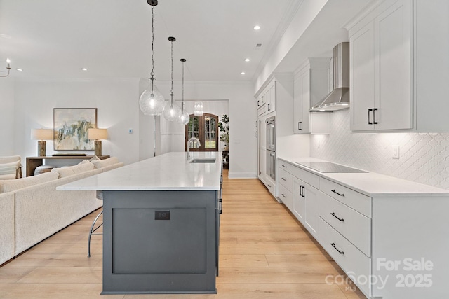 8283 Long Island Rd, Catawba, NC 28609 - kitchen with wall chimney range hood, black electric stovetop, a kitchen breakfast bar, open floor plan, and white cabinetry