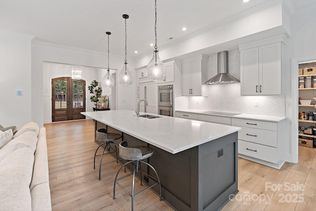 8283 Long Island Rd, Catawba, NC 28609 - kitchen featuring wall chimney exhaust hood, black electric stovetop, a breakfast bar, light wood-style flooring, and a spacious island