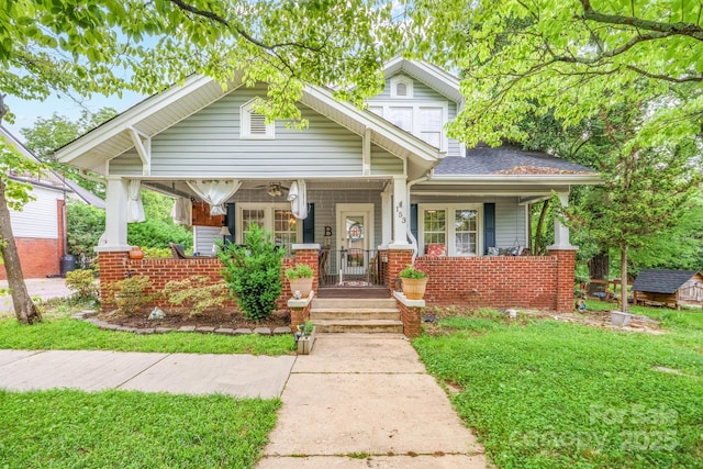 153 S Center St, Taylorsville, NC 28681 - bungalow-style house with covered porch, brick siding, a front lawn, and a shingled roof