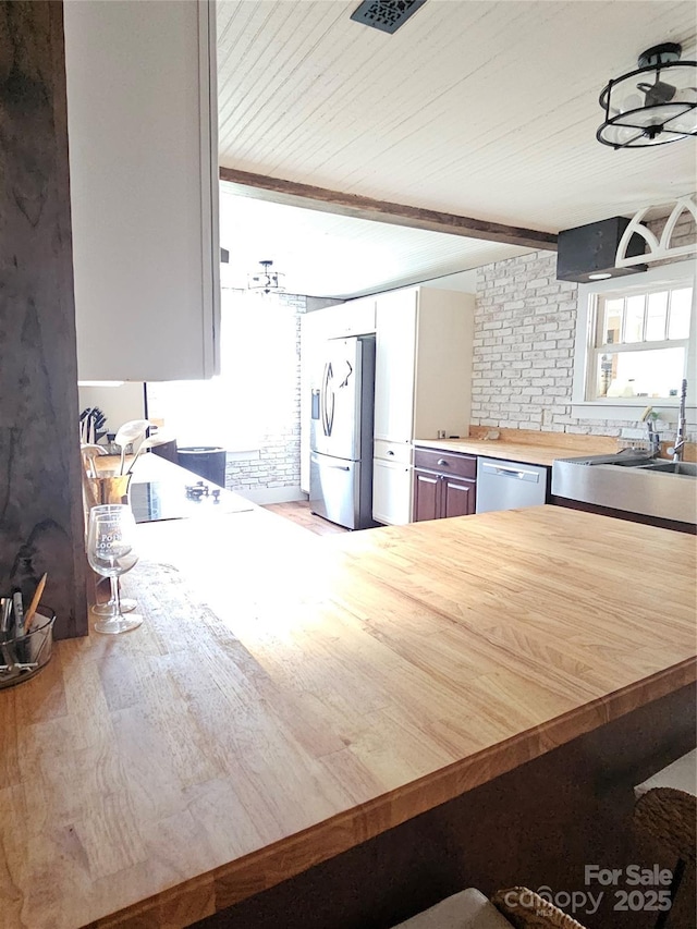 180 Vance Price Rd, Forest City, NC 28043 - kitchen with appliances with stainless steel finishes, butcher block counters, wooden ceiling with exposed beams, and wood finished floors