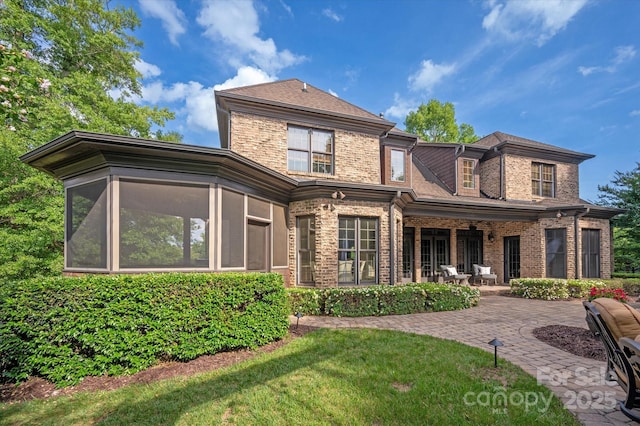 1500 Lookout Cir, Waxhaw, NC 28173 - rear view of house featuring a sunroom, brick siding, a patio, and a yard