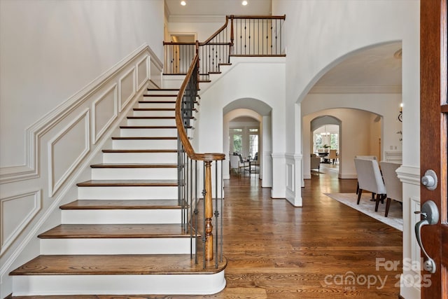 1500 Lookout Cir, Waxhaw, NC 28173 - stairway featuring arched walkways, wood finished floors, ornamental molding, and a towering ceiling