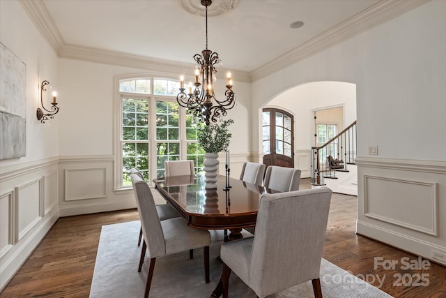 1500 Lookout Cir, Waxhaw, NC 28173 - dining room featuring dark wood-style flooring, arched walkways, a chandelier, stairway, and ornamental molding
