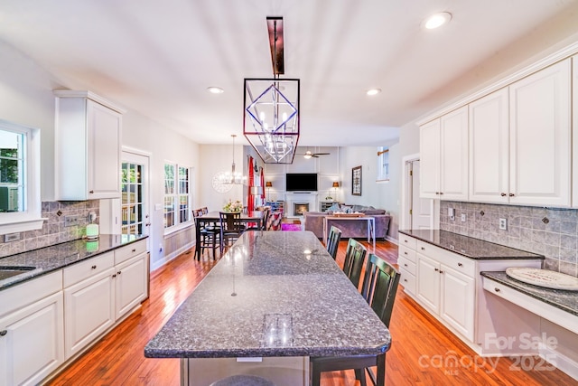 15811 Burlingame Dr, Huntersville, NC 28078 - kitchen featuring a chandelier, white cabinets, tasteful backsplash, open floor plan, and light wood finished floors
