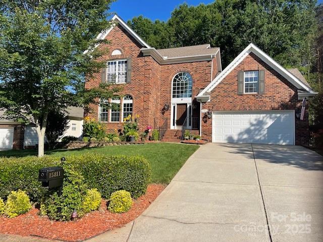 15811 Burlingame Dr, Huntersville, NC 28078 - view of front of home with concrete driveway, brick siding, a front lawn, and a garage