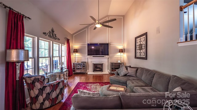 15811 Burlingame Dr, Huntersville, NC 28078 - living area featuring wood finished floors, high vaulted ceiling, a ceiling fan, and a fireplace with raised hearth
