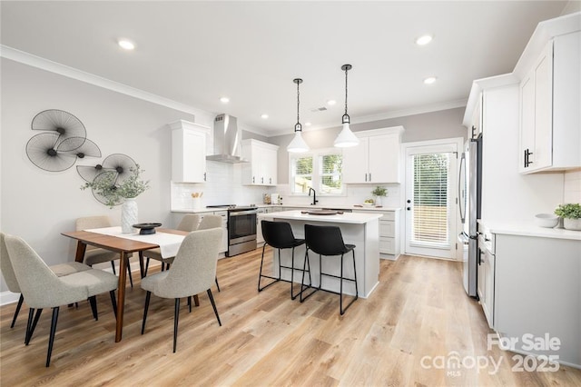 2003 Ashley Rd Unit B, Charlotte, NC 28208 - kitchen with stainless steel appliances, wall chimney exhaust hood, a kitchen bar, decorative backsplash, and ornamental molding