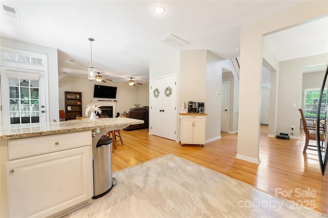 4000 Garfield Ct, Waxhaw, NC 28173 - kitchen featuring ceiling fan, a fireplace, light wood-type flooring, open floor plan, and pendant lighting