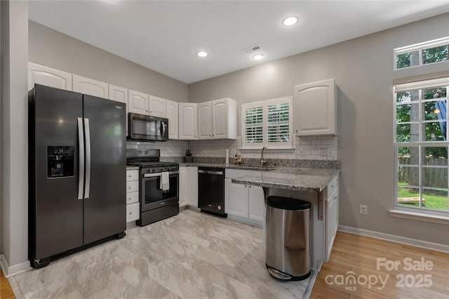 4000 Garfield Ct, Waxhaw, NC 28173 - kitchen featuring appliances with stainless steel finishes, light stone countertops, white cabinetry, backsplash, and recessed lighting