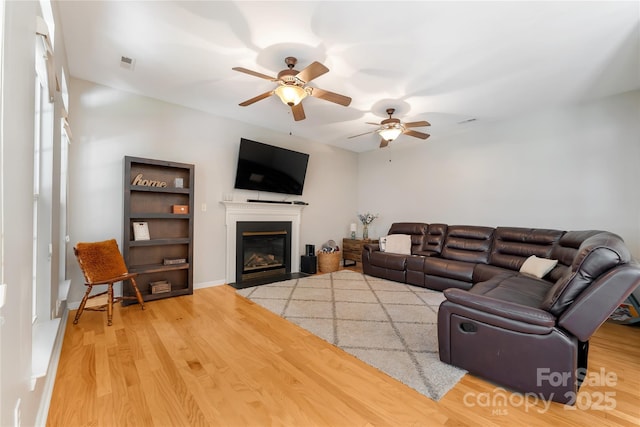 4000 Garfield Ct, Waxhaw, NC 28173 - living area with a fireplace with flush hearth, a ceiling fan, and wood finished floors