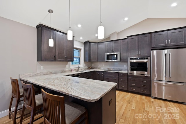 288 Ollie Weaver Rd, Weaverville, NC 28787 - kitchen featuring stainless steel appliances, lofted ceiling, dark brown cabinetry, a peninsula, and a kitchen bar