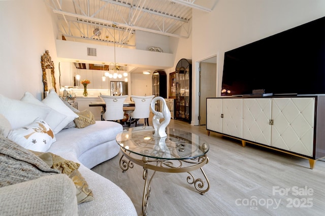 720 Governor Morrison St Unit 221, Charlotte, NC 28211 - living area with arched walkways, a towering ceiling, light wood-style floors, and a chandelier