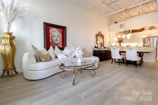 720 Governor Morrison St Unit 221, Charlotte, NC 28211 - living room with a towering ceiling, light wood-style floors, and a chandelier