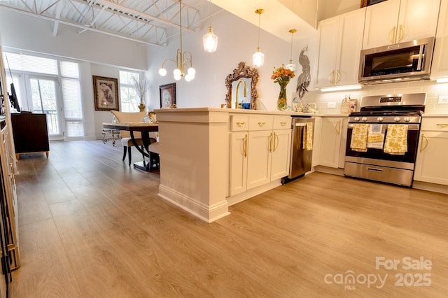 720 Governor Morrison St Unit 221, Charlotte, NC 28211 - kitchen featuring stainless steel appliances, a peninsula, high vaulted ceiling, light wood-type flooring, and backsplash