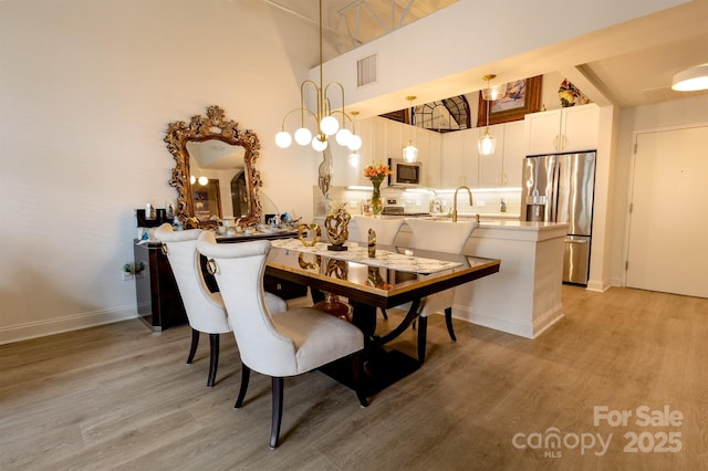 720 Governor Morrison St Unit 221, Charlotte, NC 28211 - dining space featuring light wood-type flooring and a towering ceiling