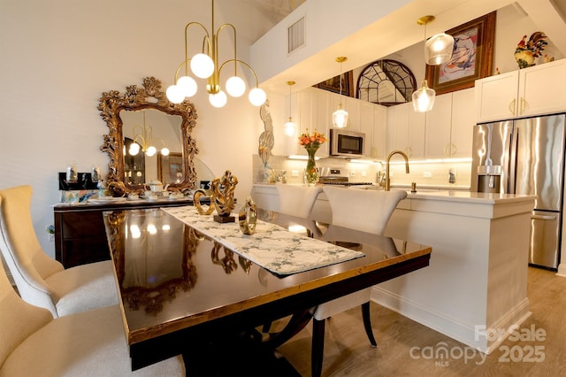 720 Governor Morrison St Unit 221, Charlotte, NC 28211 - dining room with a chandelier and light wood finished floors