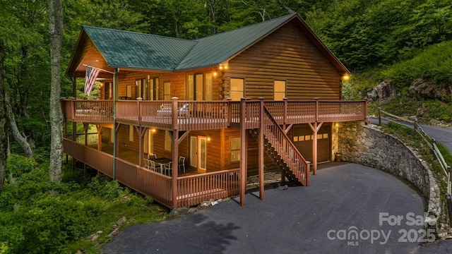 587 Grouse Thicket Rd, Mars Hill, NC 28754 - view of front of home with a deck, driveway, a metal roof, and a wooded view