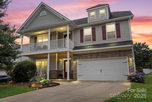 5111 Elementary View Dr, Charlotte, NC 28269 - view of front facade with a balcony, stone siding, an attached garage, driveway, and a porch