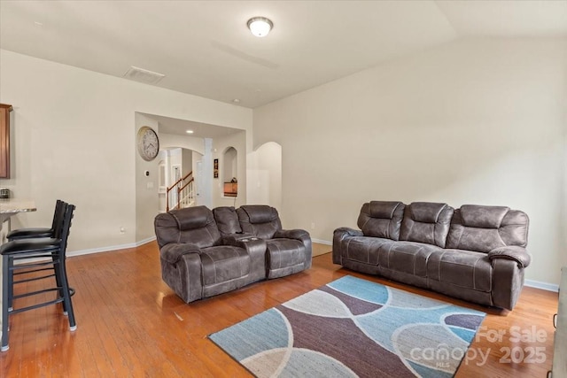 5111 Elementary View Dr, Charlotte, NC 28269 - living room featuring arched walkways, stairs, light wood-style flooring, and lofted ceiling