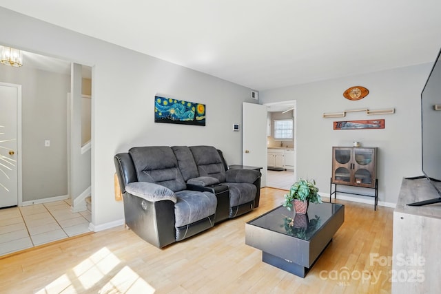 6044 Heath Valley Rd, Charlotte, NC 28210 - living room featuring light wood-type flooring, baseboards, and a chandelier