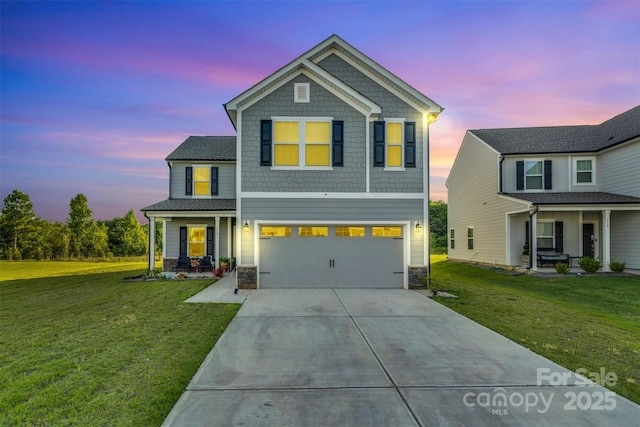112 Aspire Cir, Wingate, NC 28174 - view of front of property with covered porch, a garage, concrete driveway, stone siding, and a yard