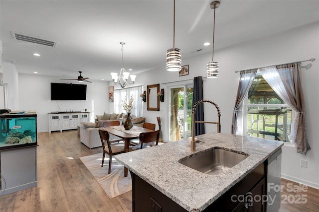 112 Aspire Cir, Wingate, NC 28174 - kitchen with stainless steel dishwasher, recessed lighting, hanging light fixtures, light wood-type flooring, and light stone counters