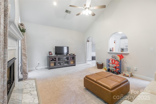 2079 Audubon Dr, Rock Hill, SC 29732 - carpeted living area featuring arched walkways, high vaulted ceiling, ceiling fan, baseboards, and a fireplace with flush hearth