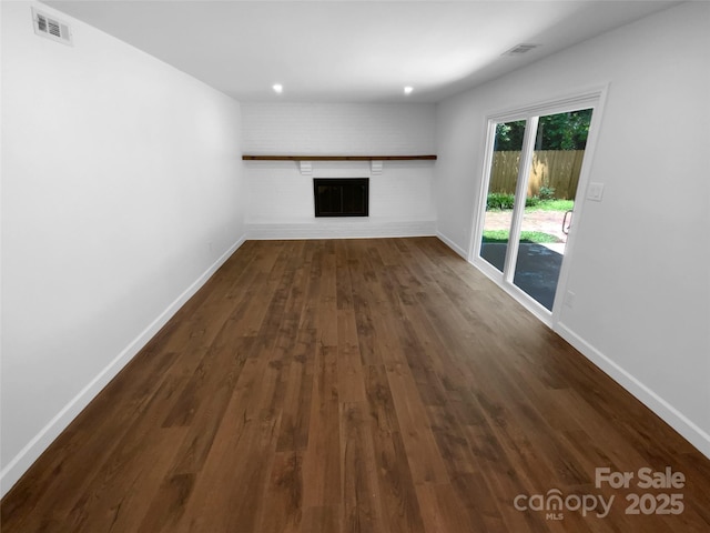 7134 Rollingridge Dr, Charlotte, NC 28211 - unfurnished living room featuring baseboards, dark wood-style flooring, and a brick fireplace