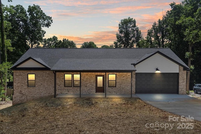 5526 Brookwood Ln, Hickory, NC 28602 - view of front of home with driveway, an attached garage, brick siding, and a shingled roof